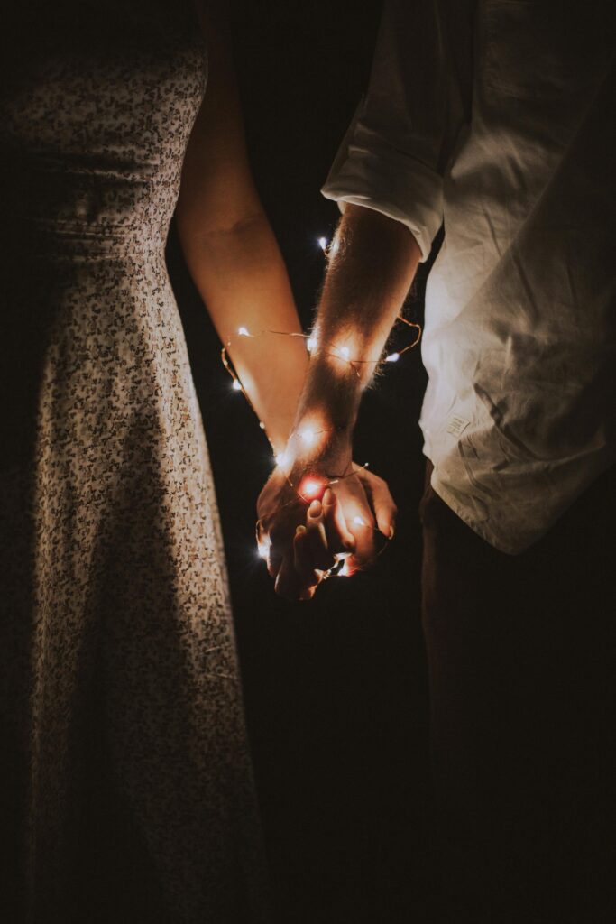 pexels-photo-792777-792777 Man and Woman Holding Each Others Hand Wrapped With String Lights